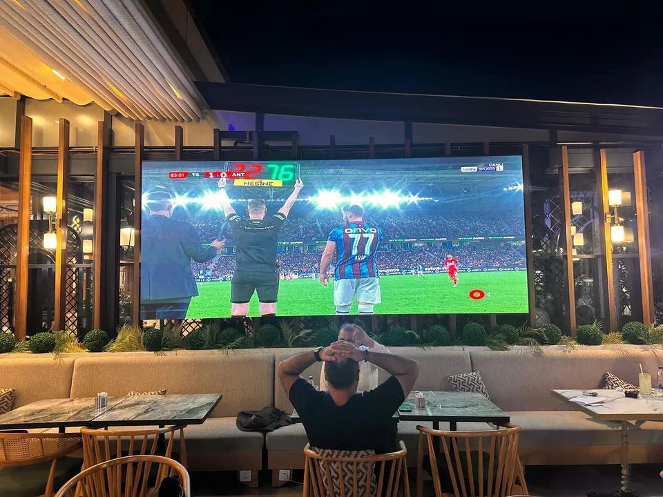 Bir lounge mekânında maç yayını yapılan iç mekân LED ekran